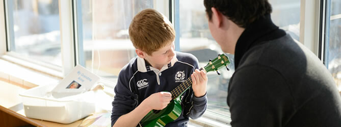 Male student playing ukulele