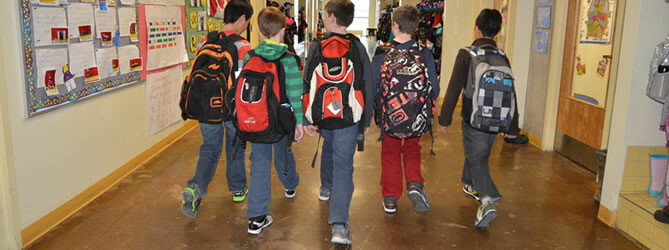 five male students salking in a school hallway