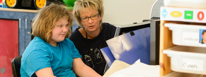 Woman helping a female student at a computer